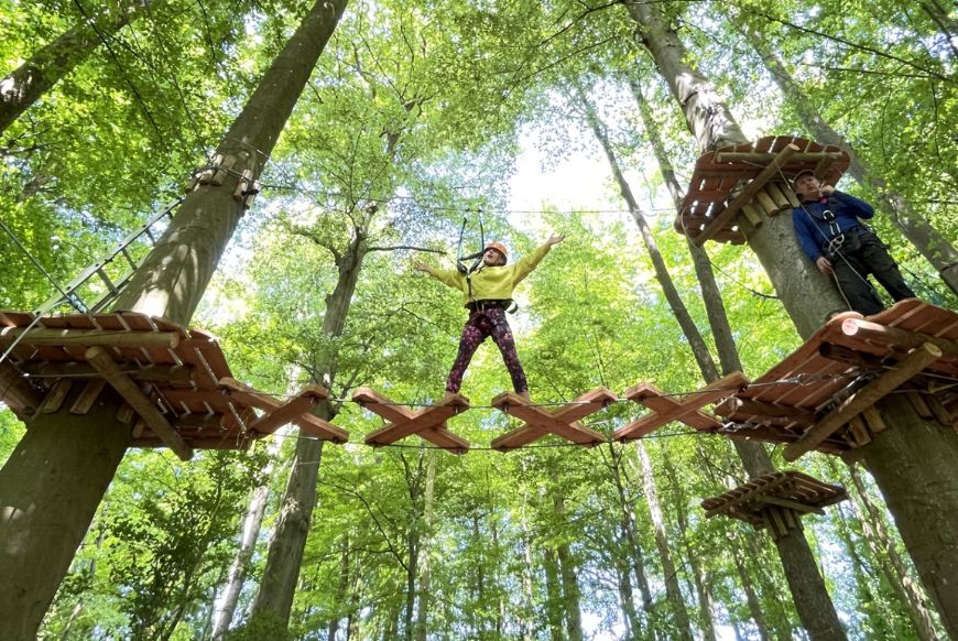 a person in the middle of a high ropes obstacle